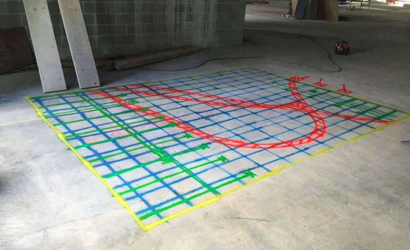 A concrete slab marked with a scanning grid showing the position of reinforcement and conduits
