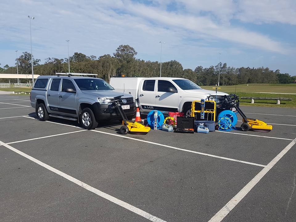Two LADS company vehicles parked on site with utility locating equipment